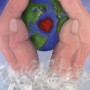 hands holding the earth with heart in the center